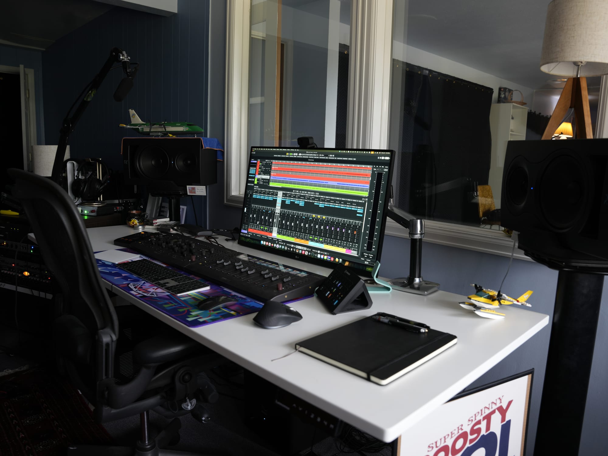 The control room desk with studio monitors, a control surface, and a DAW session open on screen.