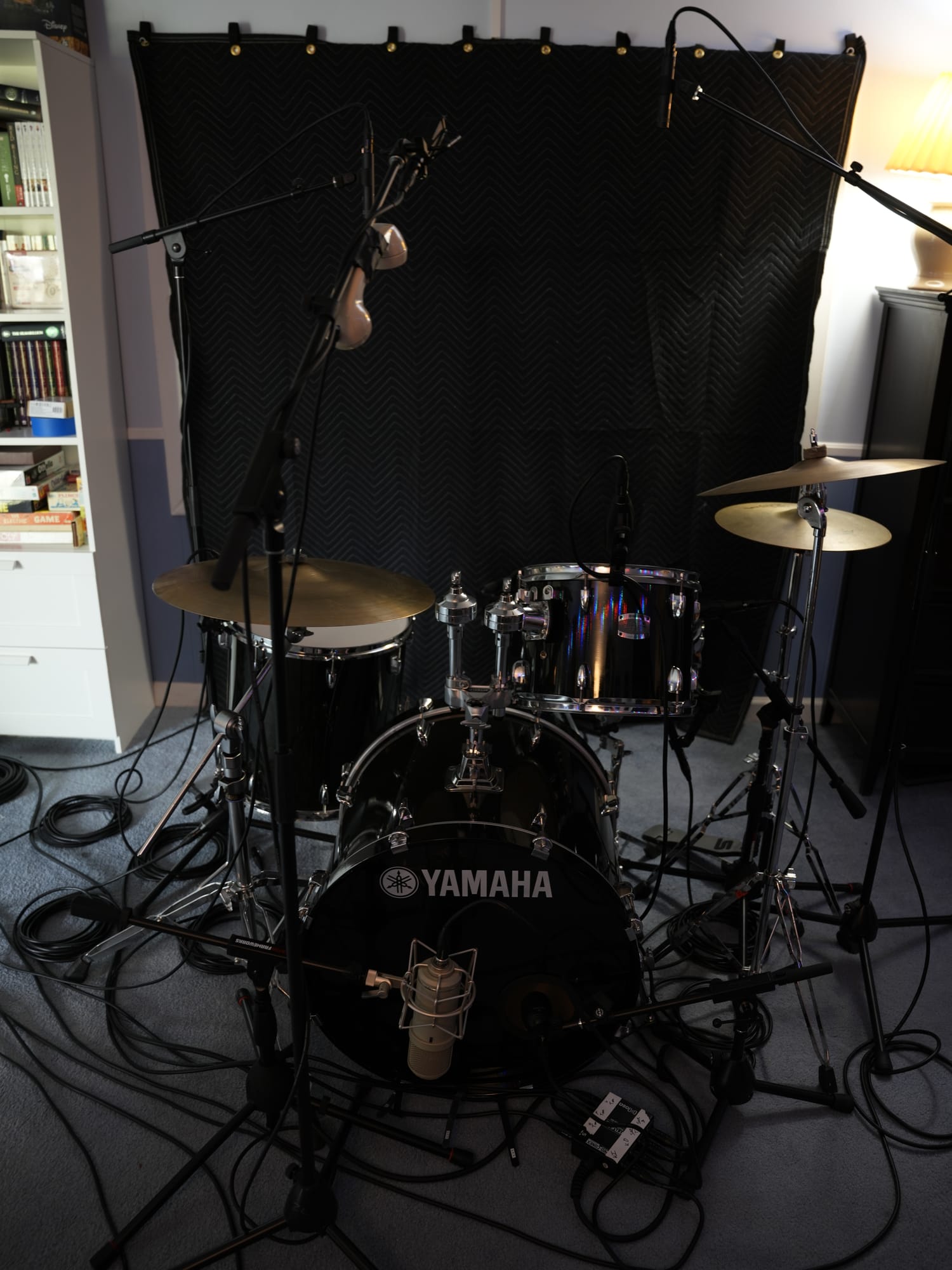A black Yamaha drum kit fully mic'd up against acoustic treatment in the live room.